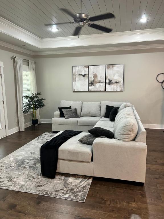 a living room with a couch and a ceiling fan at The Haven at Estuary in Huntsville