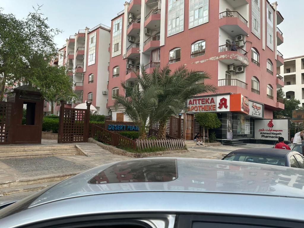 a car parked in front of a pink building at Cool Studio at nice resort with pool view in the heart of hurghada in Hurghada