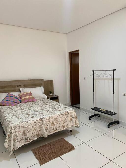 um quarto com uma cama e piso em azulejo em apartamento inteiro em Cuiabá