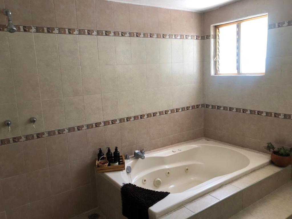 y baño con bañera y ventana. en Hostal Casa Gaia, en San Cristóbal de Las Casas