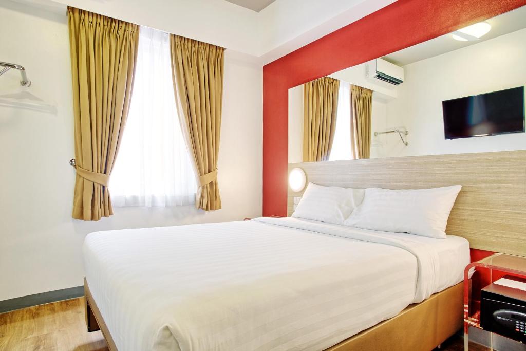 Habitación de hotel con cama y TV en Red Planet Manila Aseana City, en Manila