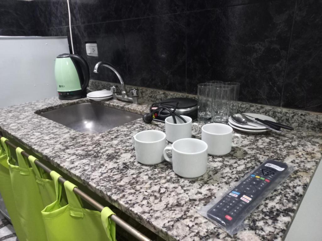 a kitchen counter with cups and a remote control on it at Mi cielo in Santa María