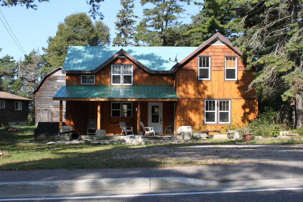a wooden house with a green roof at 4 Bedroom Cottage on Manitoulin Island Next to Sand Beaches! in Providence Bay