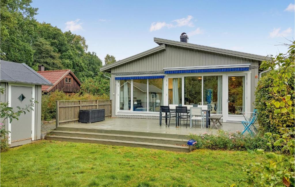 a house with a deck with chairs and a table at Amazing Home In Halmstad With Wifi in Halmstad