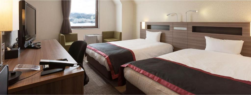 Postel nebo postele na pokoji v ubytování Onomichi Kokusai Hotel