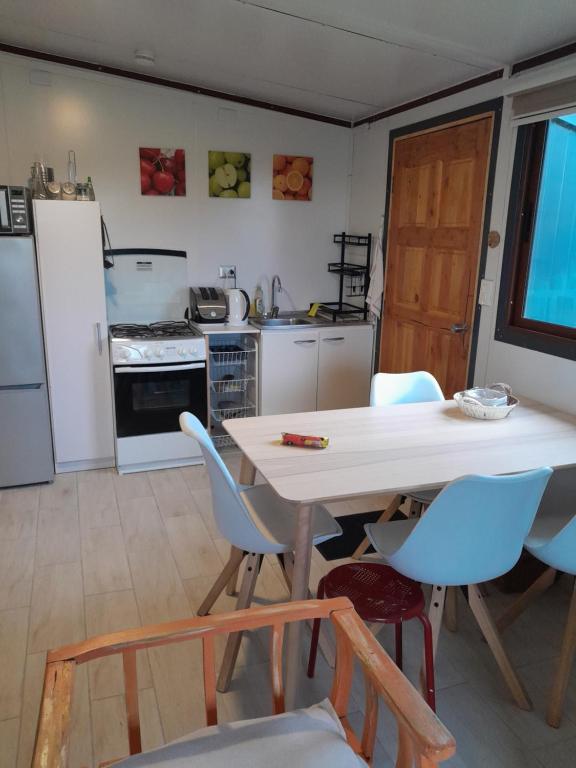 cocina con mesa blanca y sillas en Cabaña Familiar Puerto Varas, en Puerto Varas