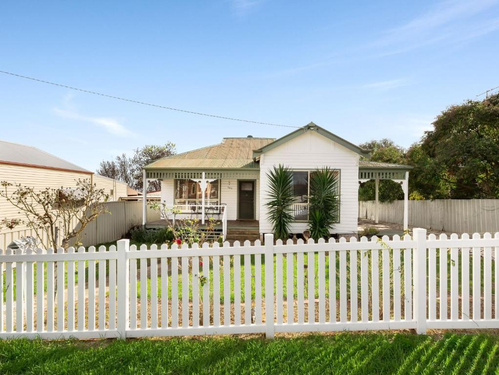 a white picket fence in front of a white house at Polly May's Rutherglen in Rutherglen