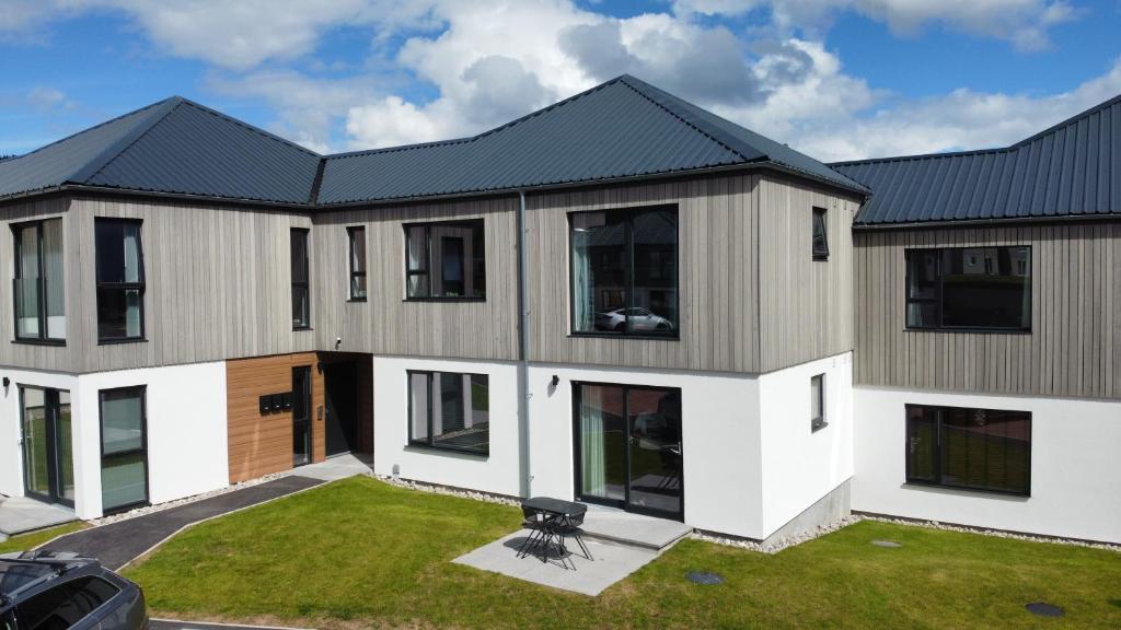 a large house with a black roof at The Peaks Three Bed Apartment in Aviemore