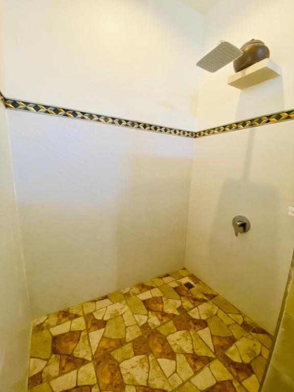 a bathroom with a shower with a tiled floor at Solaluna Beach Homestay in Amed