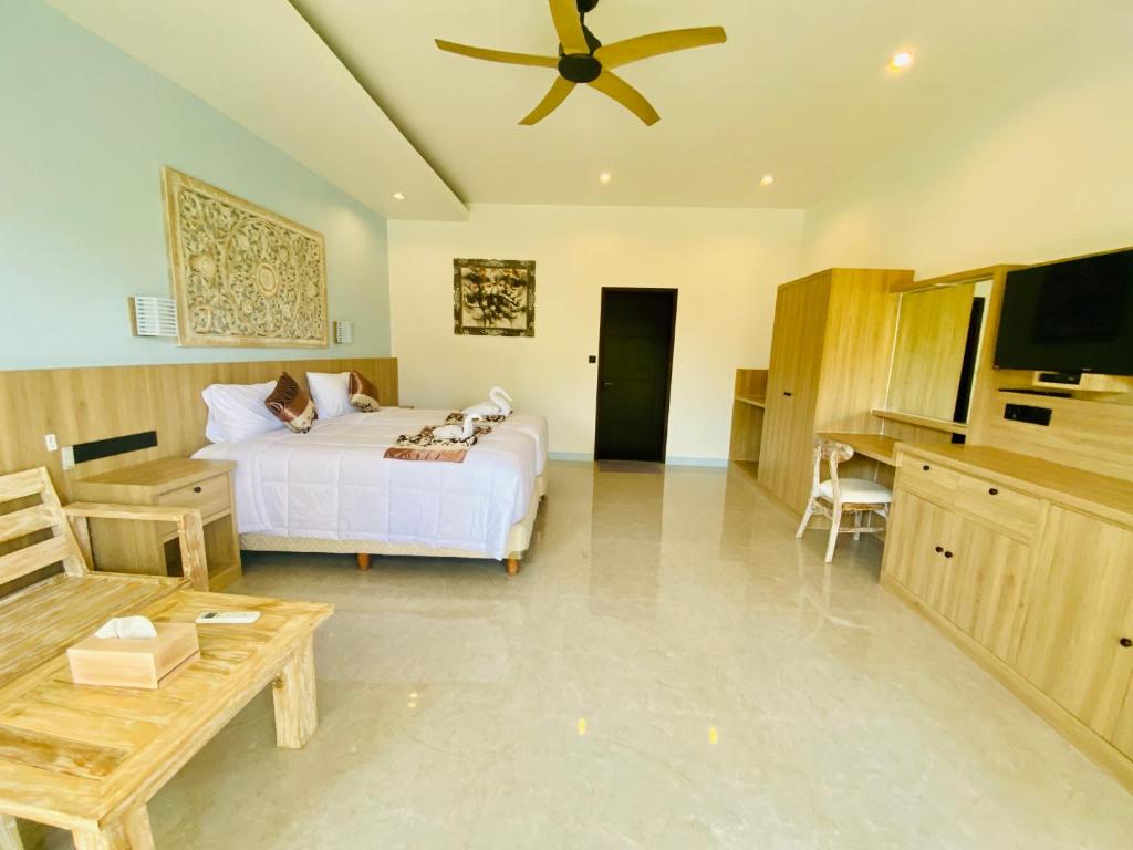 a bedroom with a bed and a ceiling fan at Solaluna Beach Homestay in Amed
