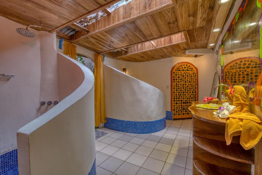 a bathroom with a shower and a tub with a sink at Tree House Beachfront Lodge in Puerto Viejo