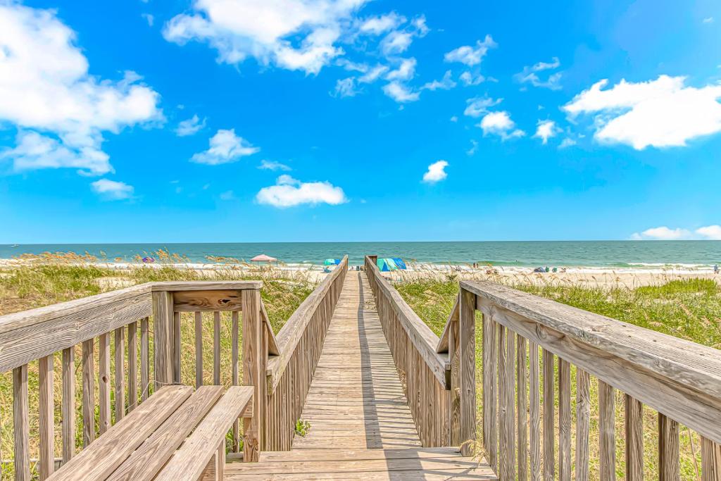 a boardwalk to the beach with the ocean in the background at Cozy Condo, Beach Access, Dock, Pool, Sunsets in Myrtle Beach