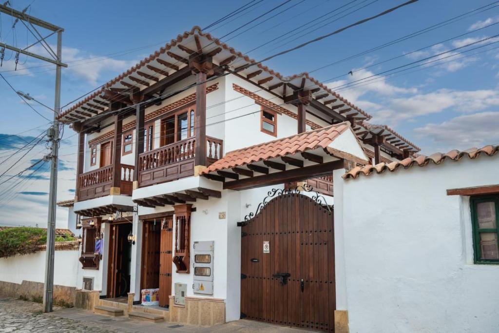 uma casa com um portão de madeira e telhado de madeira em HOTEL ALTIPLANO VILLA DE LEYVA em Villa de Leyva