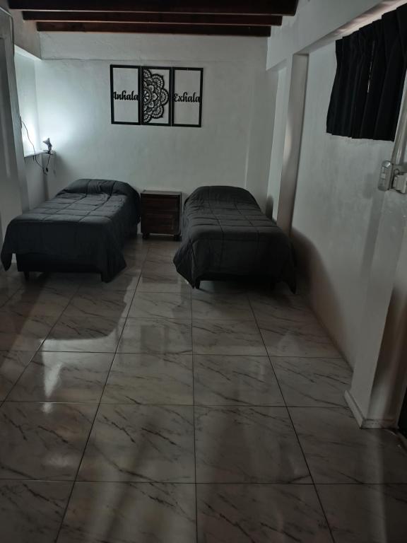 Habitación con 2 camas y suelo de baldosa. en Monoambiente excelente ubicación no mascotas en Mendoza