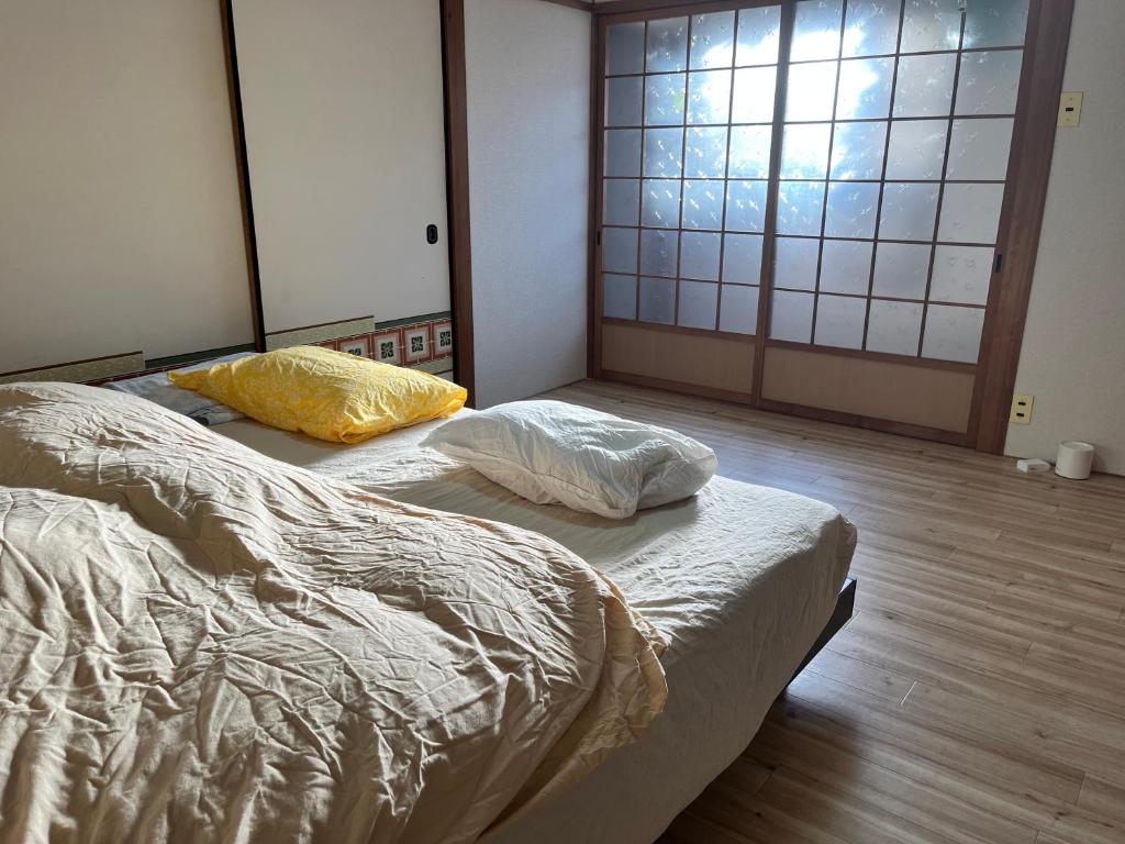 Postel nebo postele na pokoji v ubytování シェアする子育て すいまーる Suimaaru