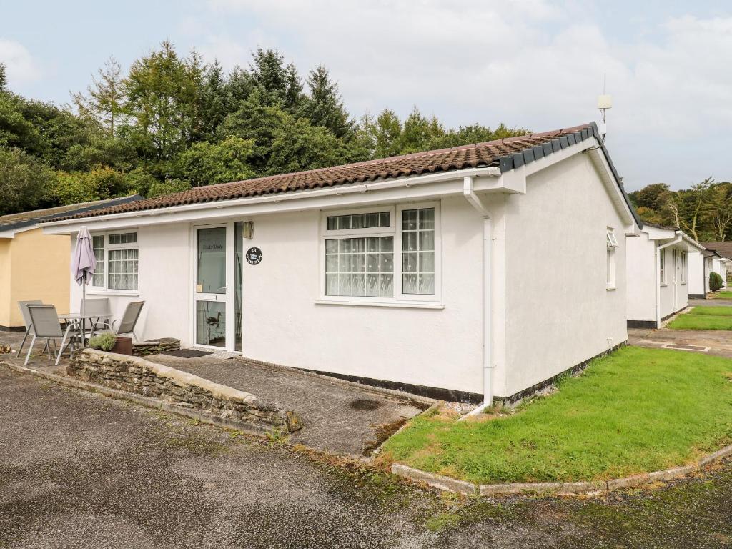 a white house with a yard and a driveway at Ducks Ditty in Liskeard