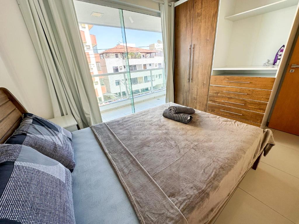 a bedroom with a bed with a large window at Luz do Sol Prainha - 3 Quartos in Arraial do Cabo