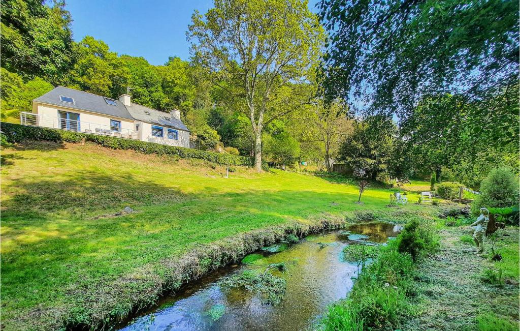 a house on a hill next to a river at Beautiful Home In Plouigneau With Kitchen in Plouigneau