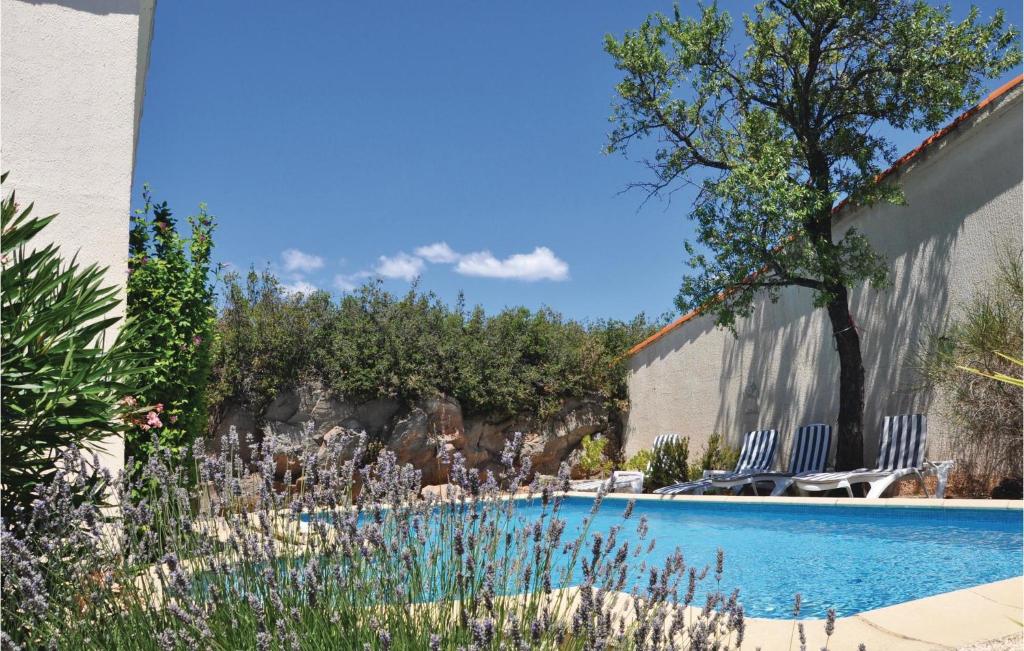- une piscine dans une cour avec des chaises et un arbre dans l'établissement Awesome Home In Pouzols-Minervois, à Pouzols-Minervois
