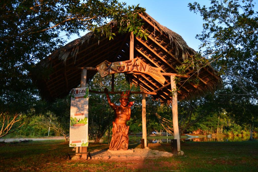 a statue of a person standing under a hut at KOFAN Ecohotel in Puerto Asís