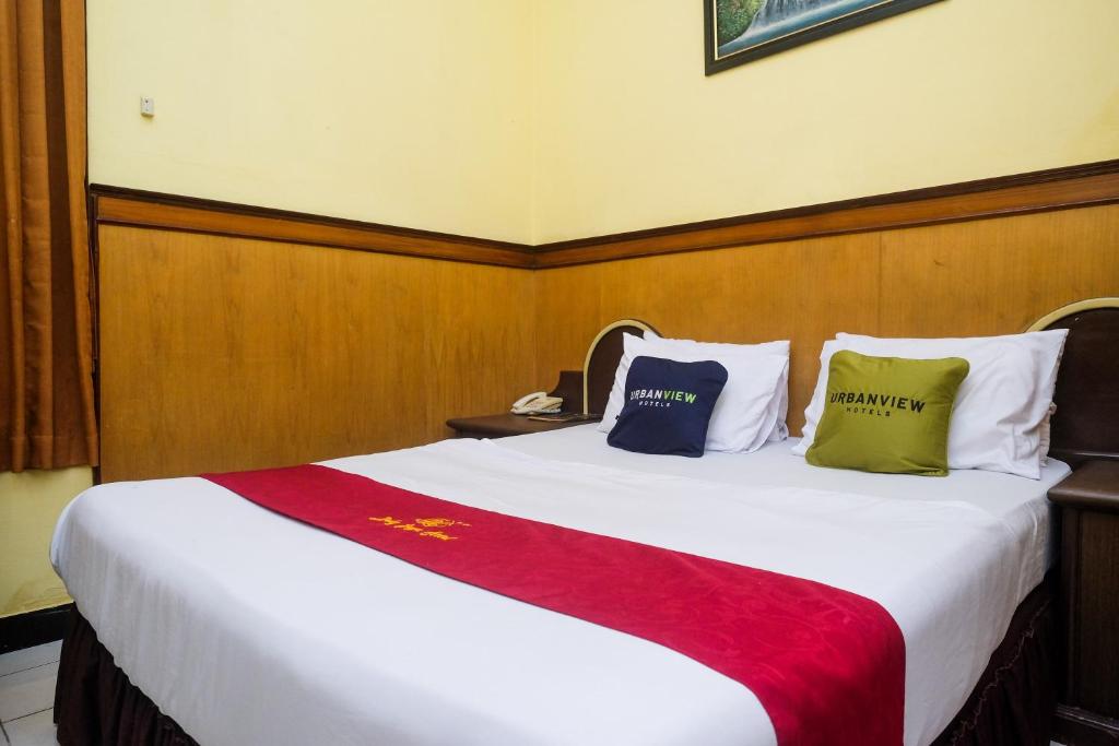 a bedroom with a large white bed with two pillows at Urbanview Hotel Dedy Jaya Brebes in Brebes