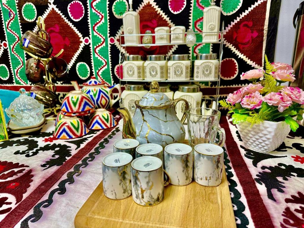 a group of cups on a table with a vase at Guest house by Sayohati Diyor in Dushanbe