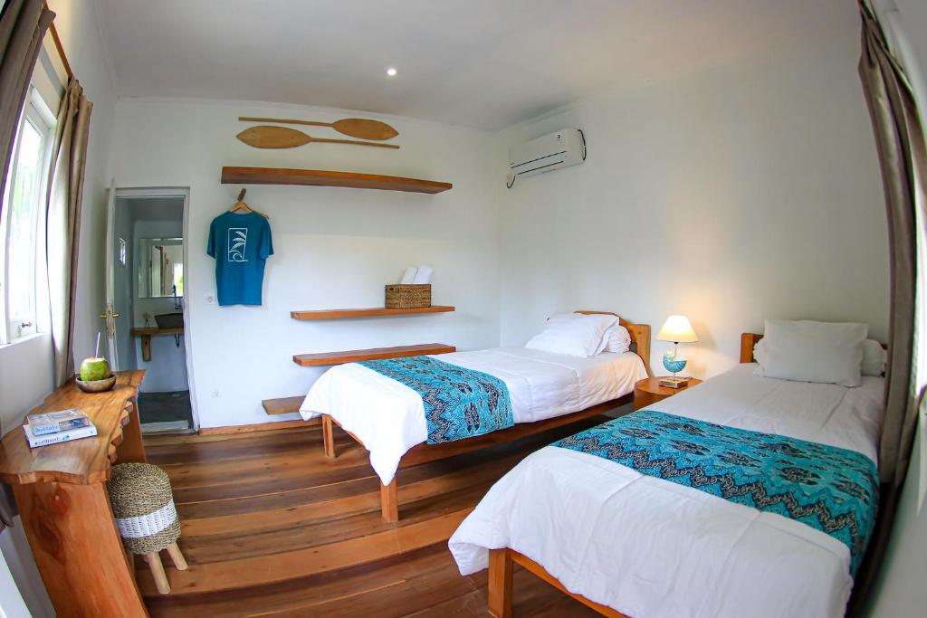 une chambre d'hôtel avec deux lits et une chambre avec dans l'établissement Katiet Beach Resort Mentawai Lances Right HTS, à Katiet