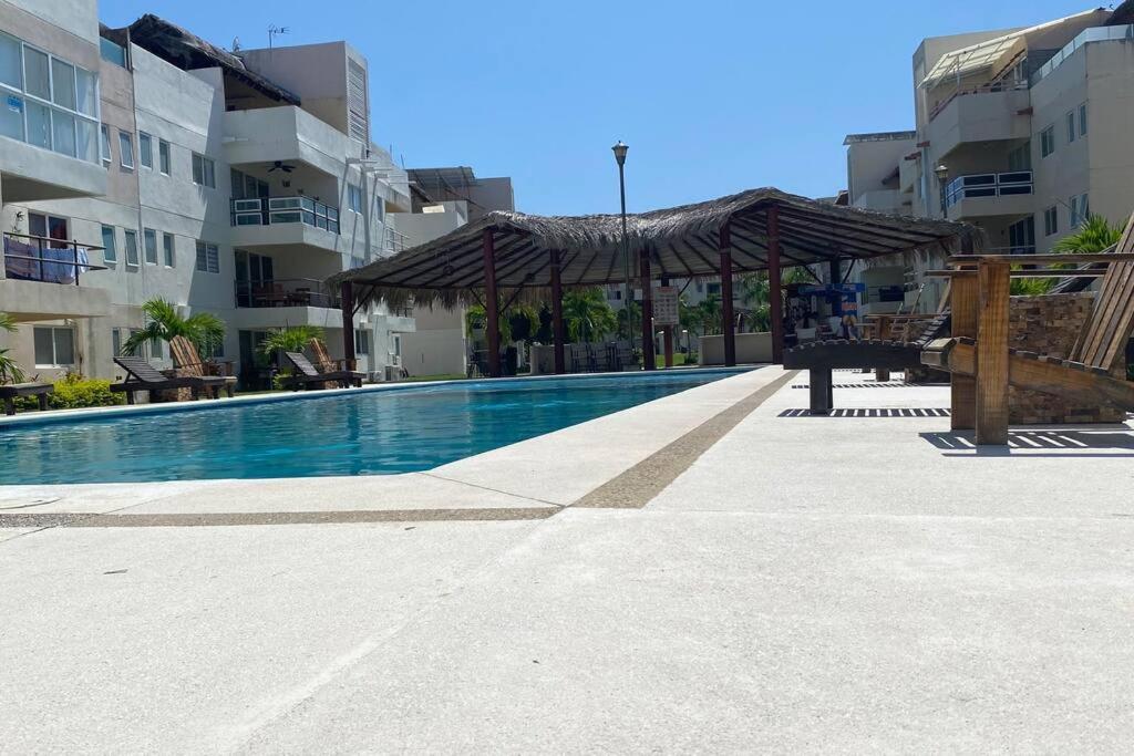 - une piscine avec un kiosque à côté de certains bâtiments dans l'établissement Departamento en Acapulco Diamante MacMac, à Acapulco