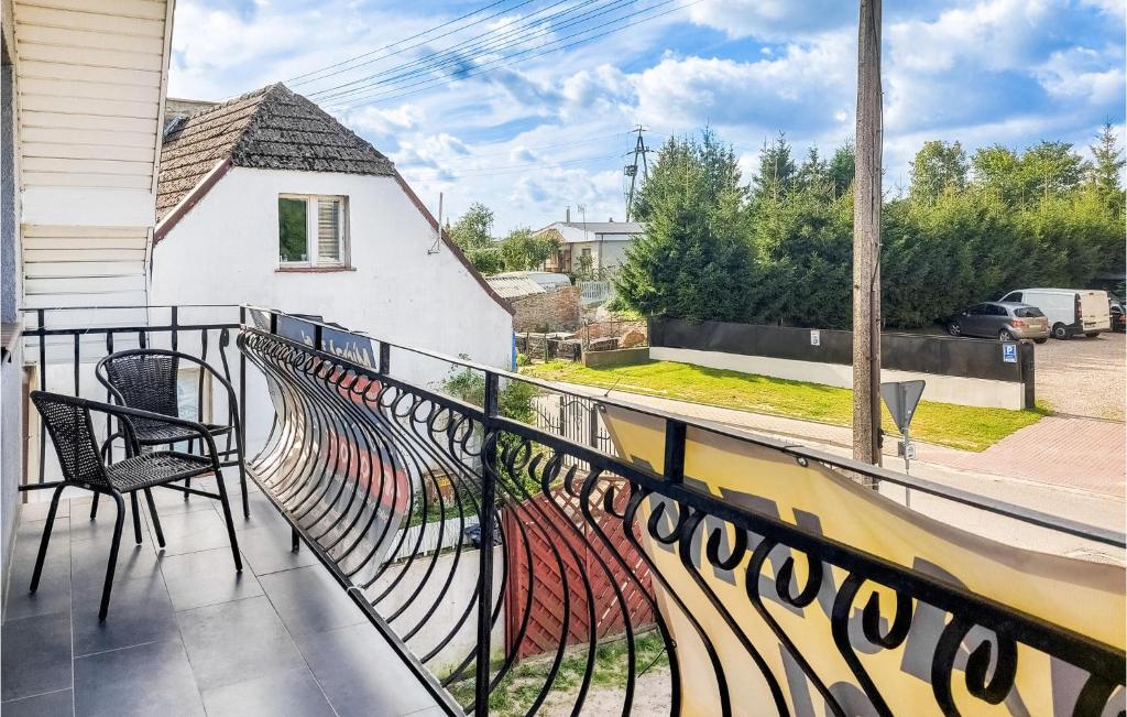 a balcony with a black railing and chairs on it at 3 Bedroom Beautiful Apartment In Wiselka in Wisełka