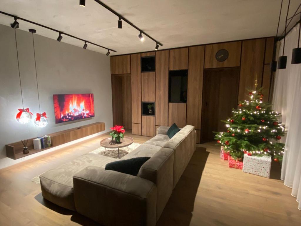 een woonkamer met een kerstboom en een bank bij Feel in forest in Vilnius