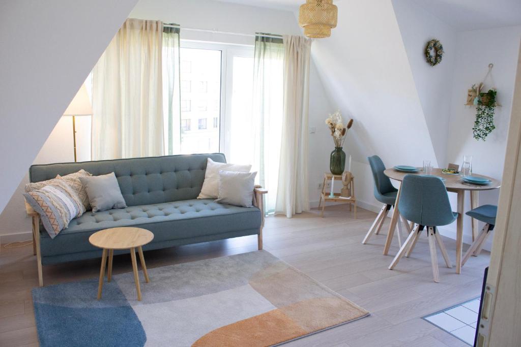 ein Wohnzimmer mit einem blauen Sofa und einem Tisch in der Unterkunft NOVA - See APT 22 I Phantasialand I Cologne I Bonn in Erftstadt