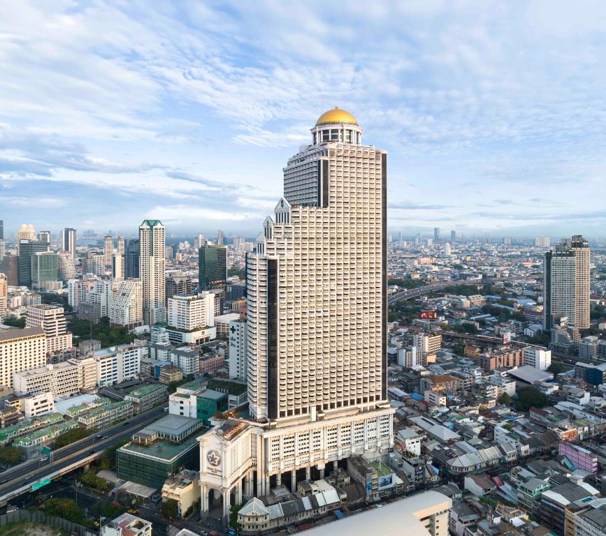 ein hohes Gebäude mit einer goldenen Kuppel darüber in der Unterkunft lebua at State Tower in Bangkok