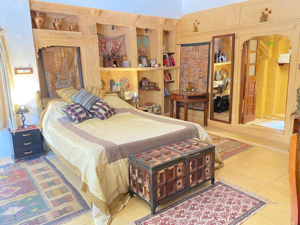 a bedroom with a bed and a table in it at Hamari Haveli in Jaisalmer