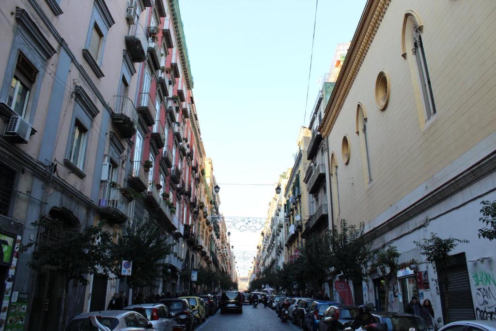 a city street with cars parked on the sides of buildings at Clelia's Room in Naples