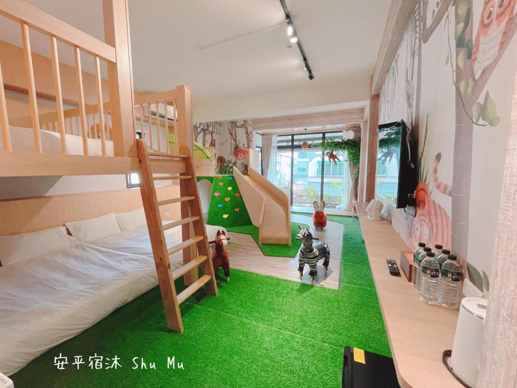 a room with a bunk bed and green carpet at Anping Su Mu in Anping