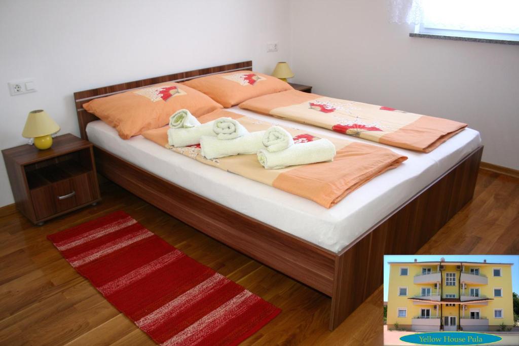 1 dormitorio con 1 cama con toallas en Yellow House Pula, en Pula
