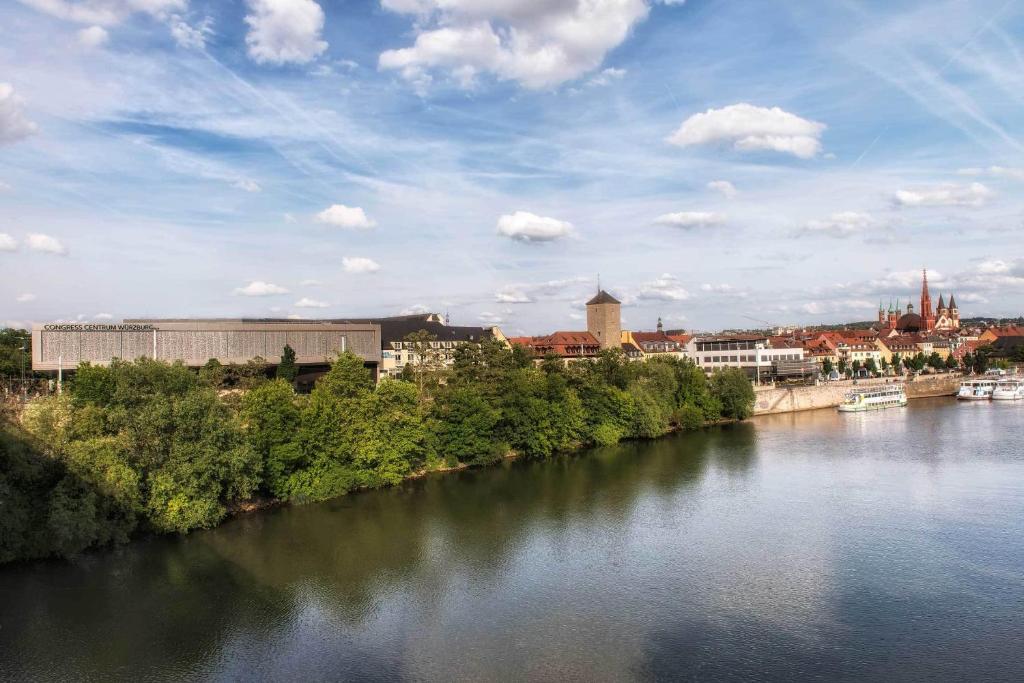 a view of a river with a city in the background at Maritim Hotel Würzburg in Würzburg