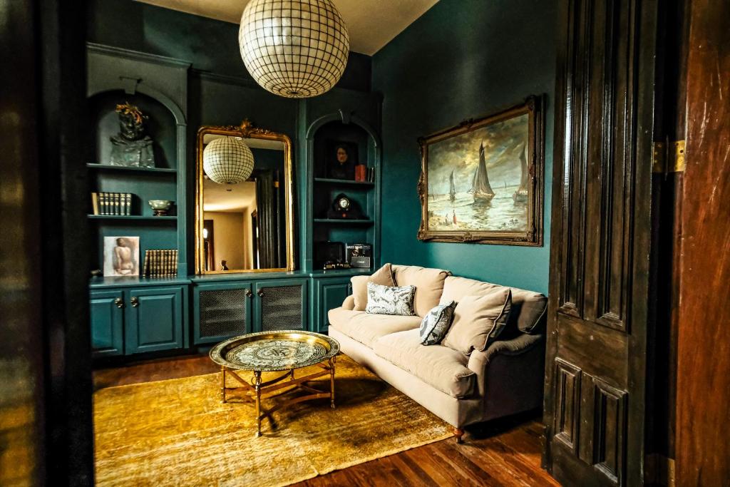 una sala de estar con un sofá y una mesa en Henrie House I Luxury 4BR Downtown Historic Gem with Library & Patio, en Nashville