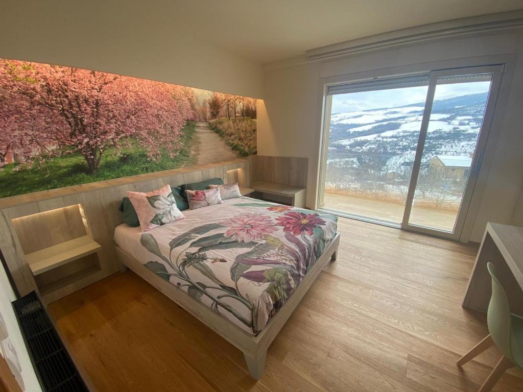 1 dormitorio con 1 cama con una pintura en la pared en Le stagioni della vita en Bovino