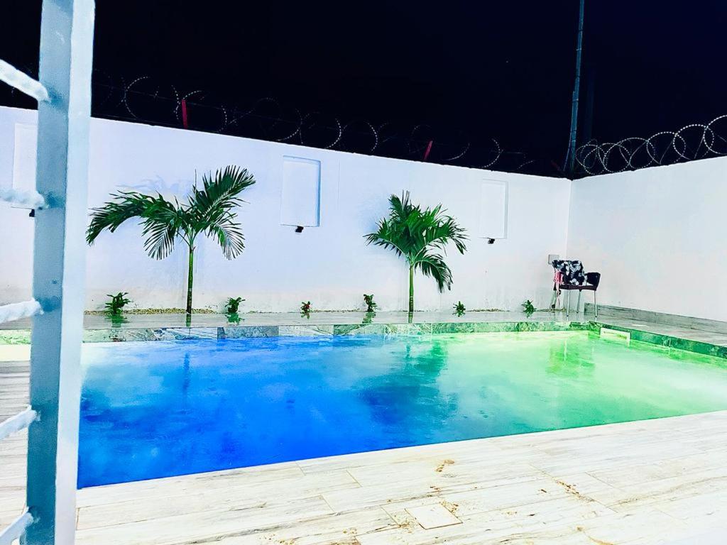 een groot zwembad met palmbomen in een kamer bij Villa avec piscine in Somone