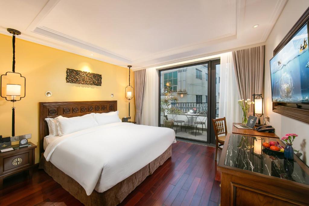 a hotel room with a bed and a large window at Lucien Hanoi Lakeside Hotel & Rooftop in Hanoi