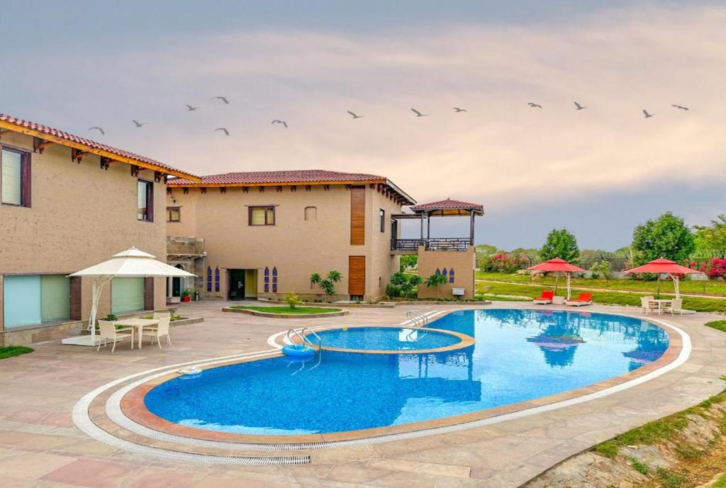 a swimming pool in front of a house at AamaGhati Wildlife Resort, Ranthambore in Sawāi Mādhopur
