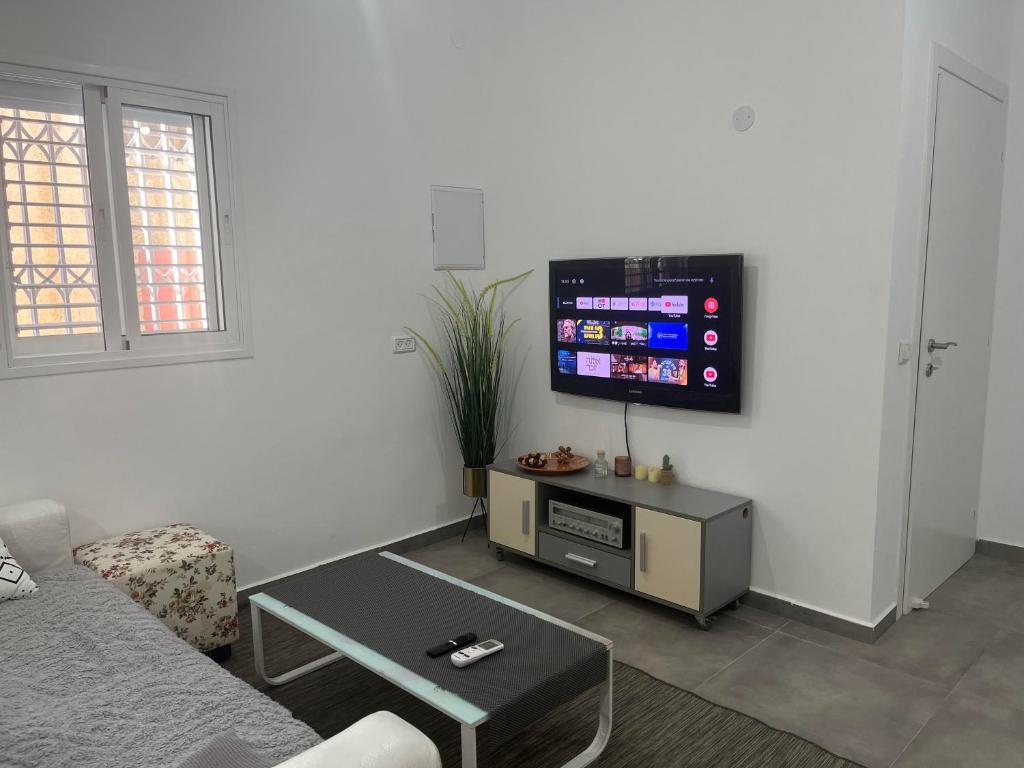 a living room with a couch and a flat screen tv at Simply Elegant in Tel Aviv