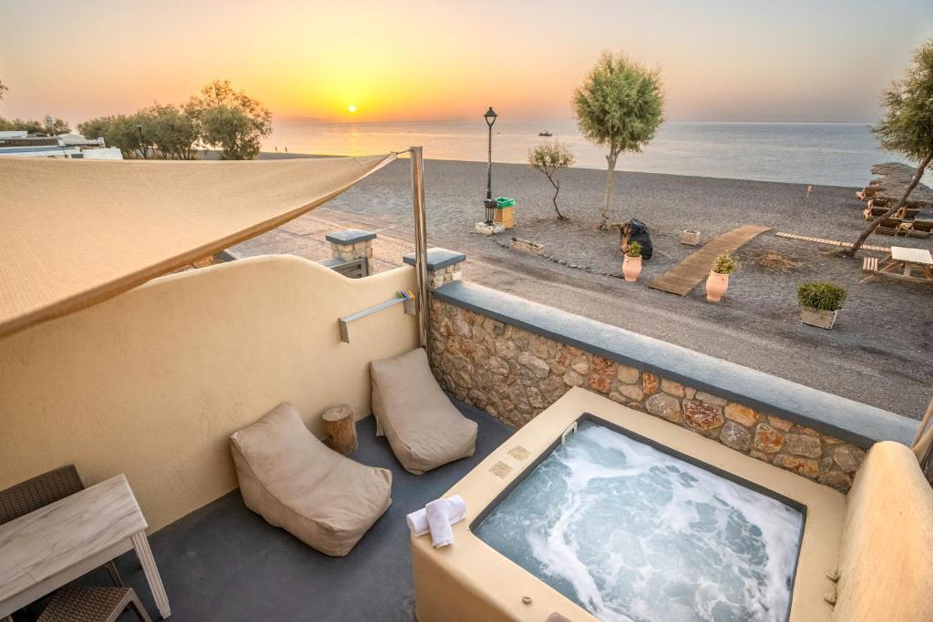 einen Whirlpool auf dem Balkon mit Blick auf den Strand in der Unterkunft Cyclops Beach Apartments in Perivolos