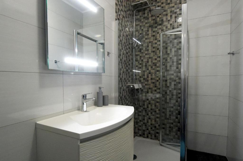 biała łazienka z umywalką i prysznicem w obiekcie Apartman Paštura w mieście Vodnjan