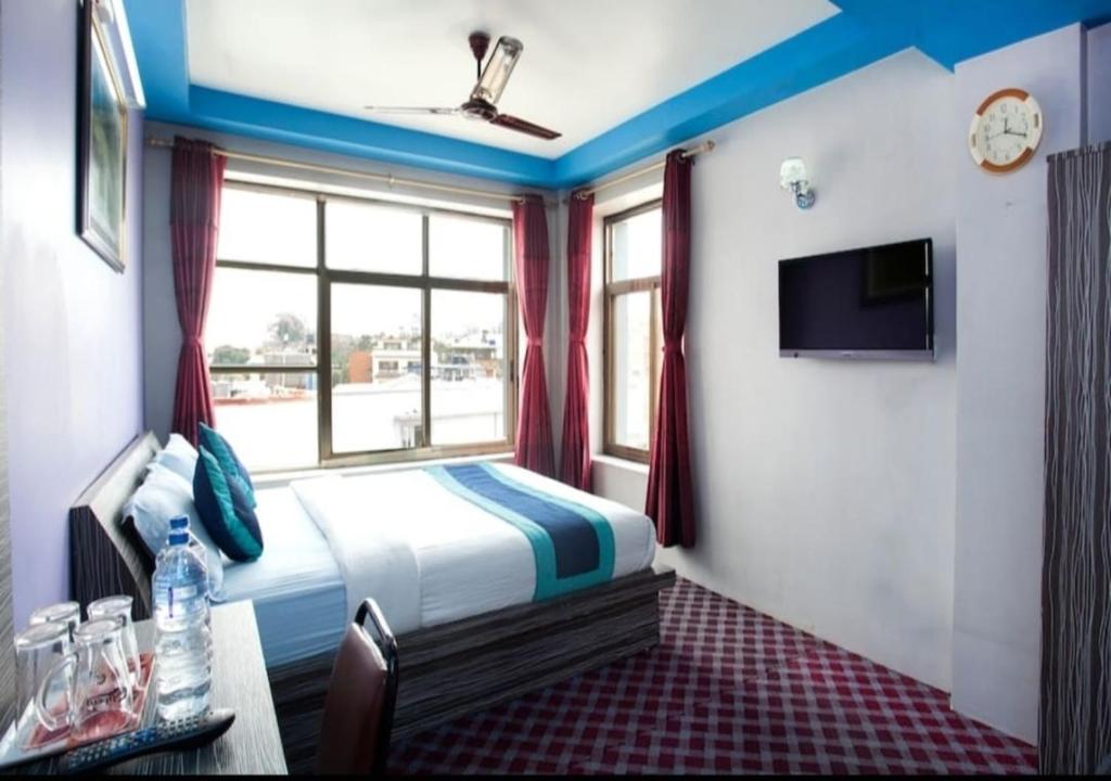 a hotel room with a bed and a window at Three Brothers Apartment and Hotel in Kathmandu