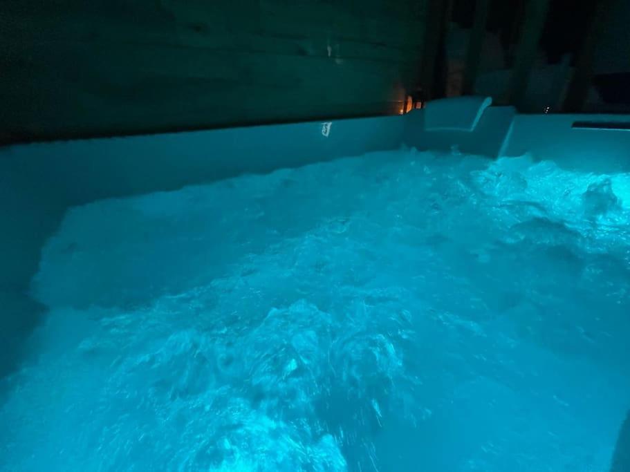 a swimming pool with blue water in it at Zen Room in LʼIsle-sur-le-Doubs