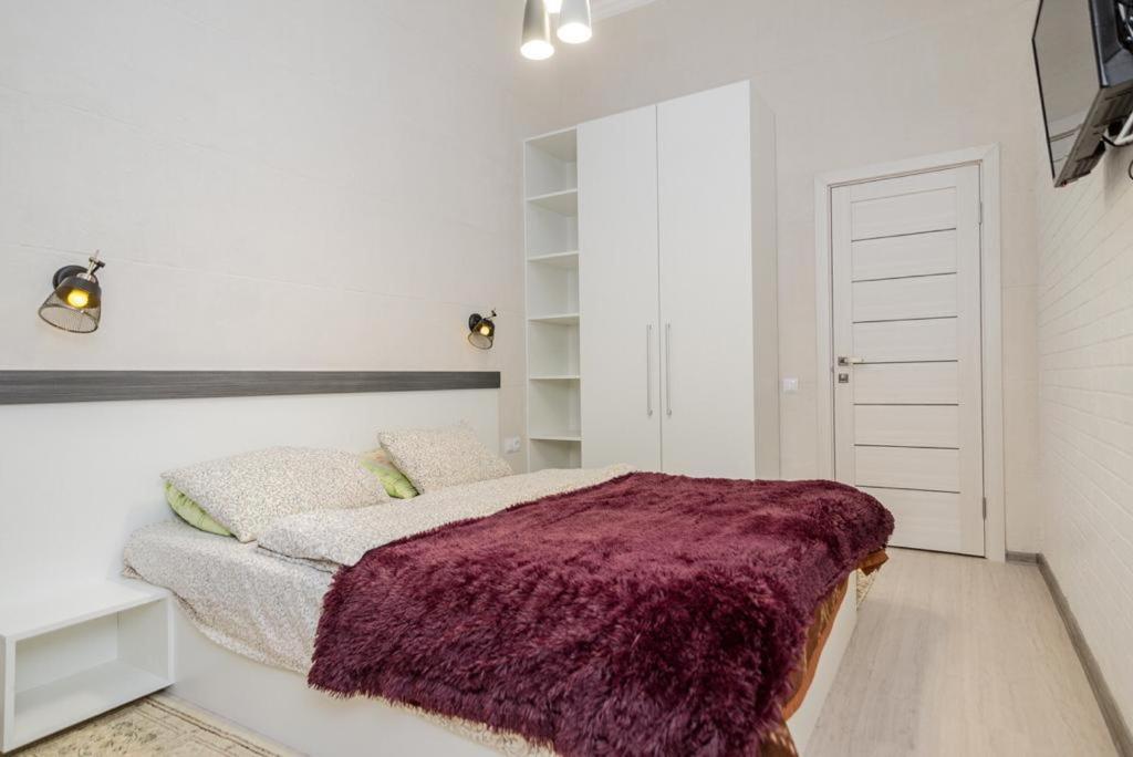 - une chambre avec un lit et une couverture violette dans l'établissement Studio Rentals, à Chişinău