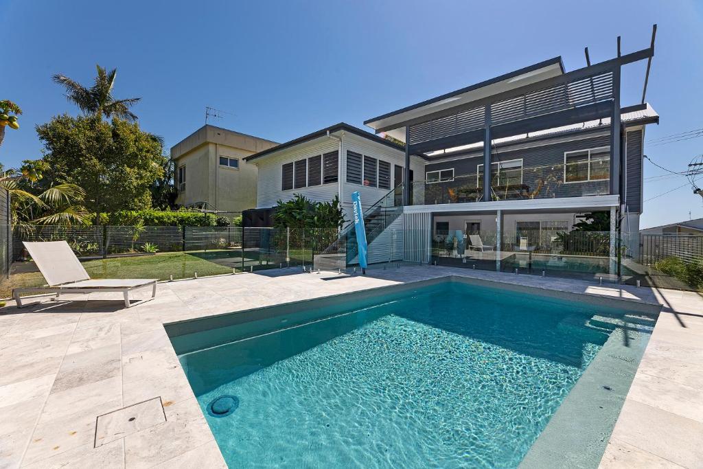a house with a swimming pool in front of a house at Serendipity in Forster
