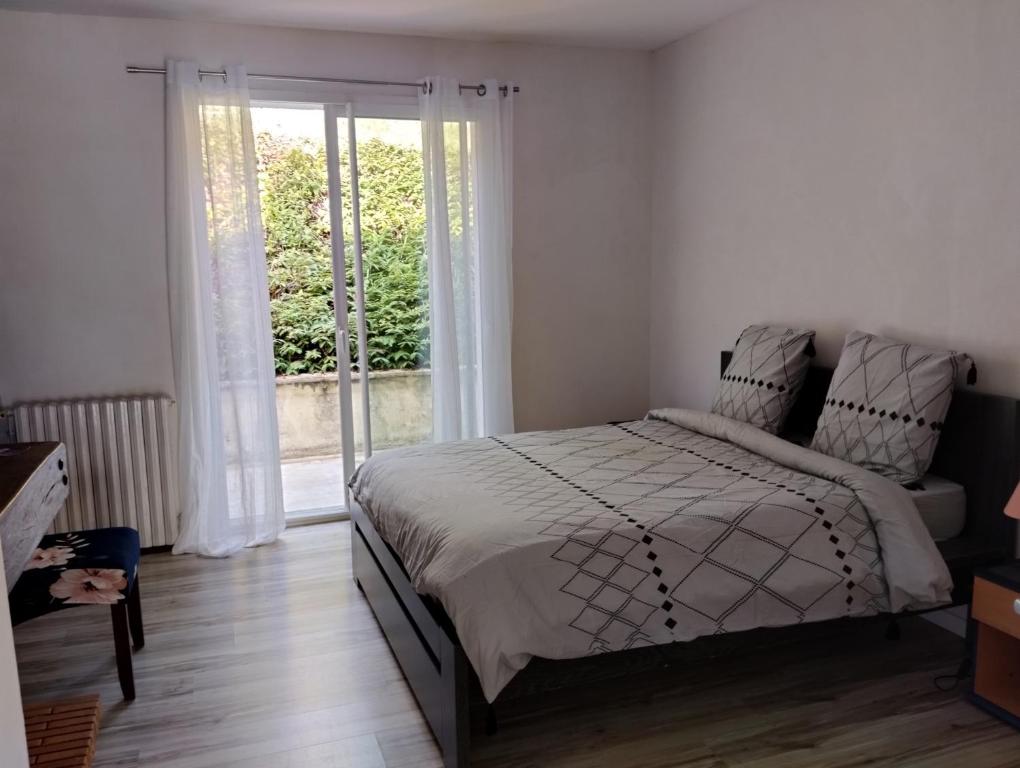 een slaapkamer met een bed en een groot raam bij VILLA DU BIEN ËTRE in Argenton-sur-Creuse